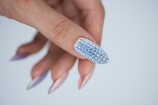 Dłoń z paznokciem w całości wyklejonym jasnoniebieskimi kryształkami Pastel Blue