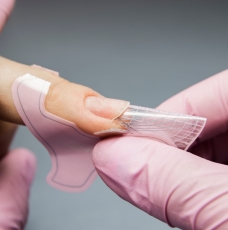Plastikowy szablon założony na palec – przedłużanie paznokcia, zbliżenie