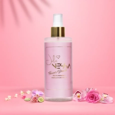 Butelka perfumowanej mgiełki do ciała Flower Dream na różowym tle z kwiatami