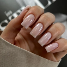 Dłoń z kwadratowymi paznokciami w kolorze bazy hybrydowej Naked Base Porcelain Milky Pink