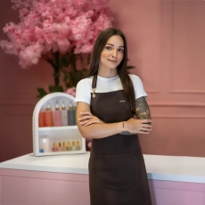 Stylistka w czekoladowym fartuszku kosmetycznym z logo Julia Nessa