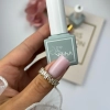 Dłoń z mlecznoróżowym paznokciem i buteleczka płynnego akrylożelu Liquid AcrylicGel Milky Pink