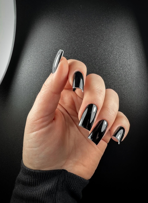 Manicure z użyciem lakieru hybrydowego NessaUV lac 604 Perfect Black na długich paznokciach na tle czerni
