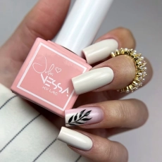 Manicure wykonany lakierem hybrydowym NessaUV lac 610, kremowo-beżowe paznokcie i zdobienie z liściem