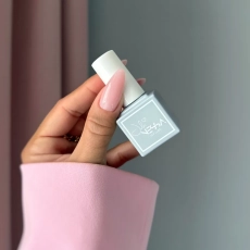 Dłoń z eleganckim manicure wykonanym płynnym akrylożelem Liquid AcrylicGel Soft Pink 50 ml, trzymająca buteleczkę Julia Nessa
